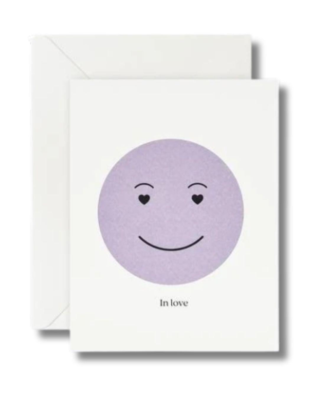 Greeting card with a purple smiley face and 'In love' text on a white background