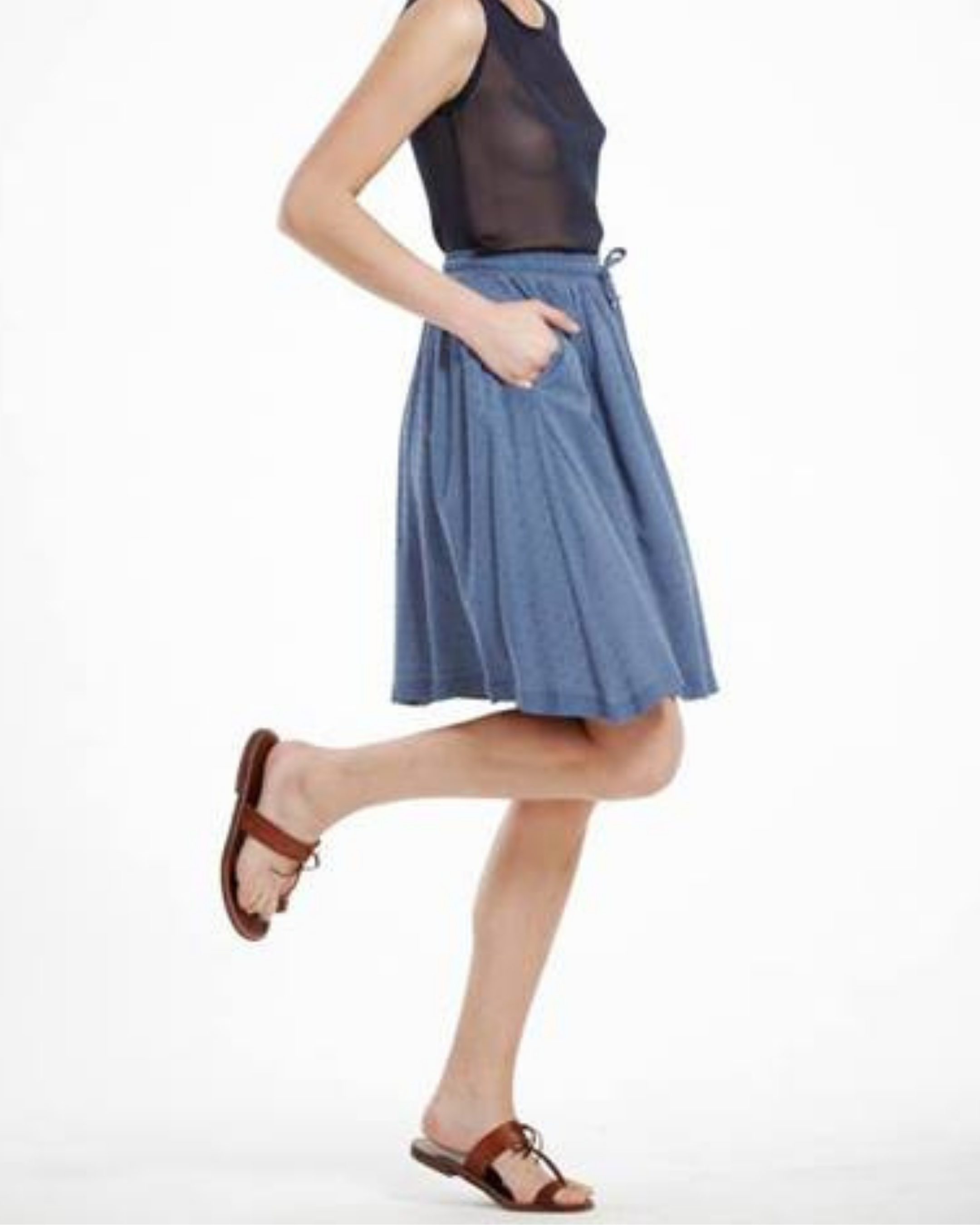 Person wearing a blue skirt and black top on a white background