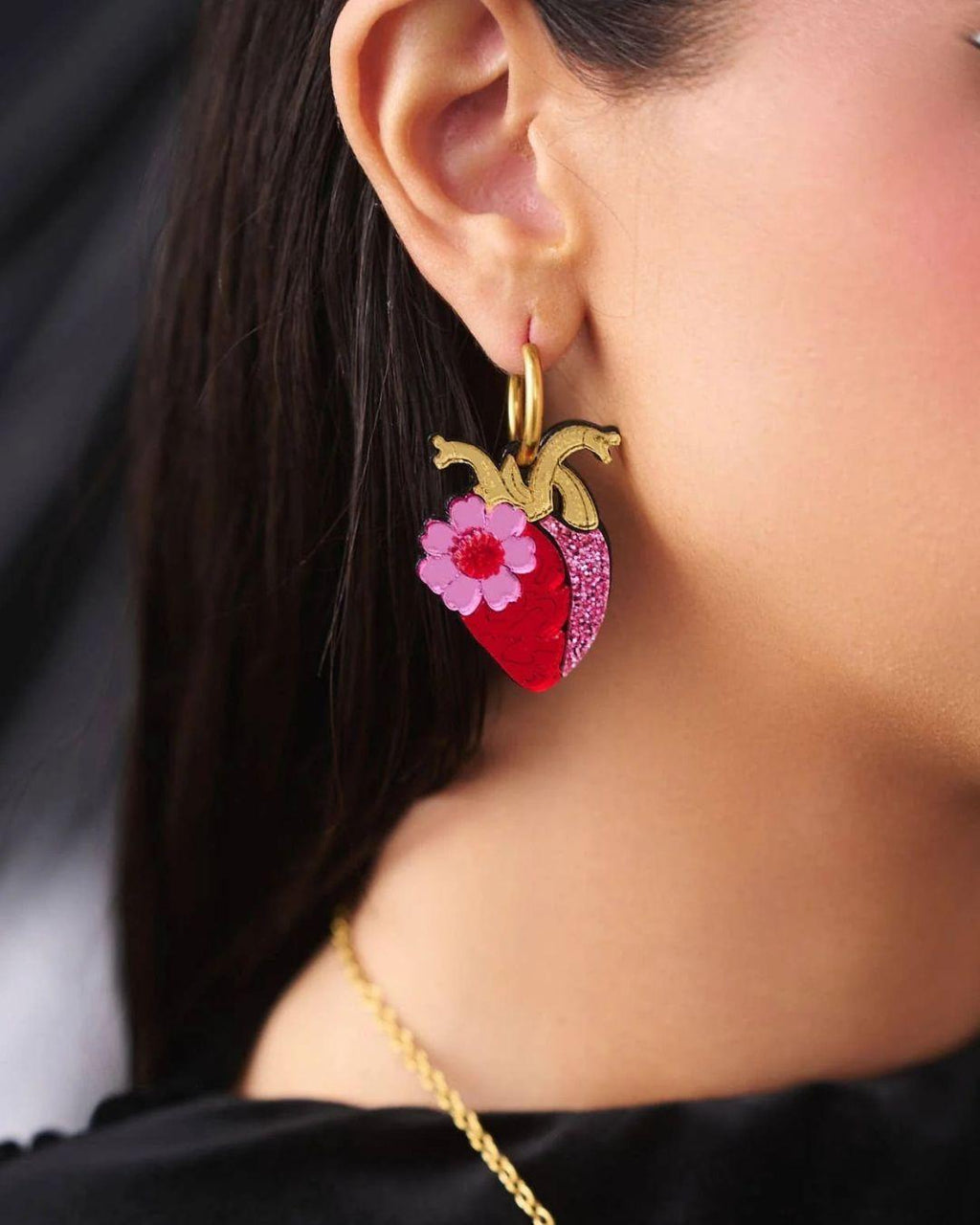 Close-up of a person wearing anatomical heart hoop earring 