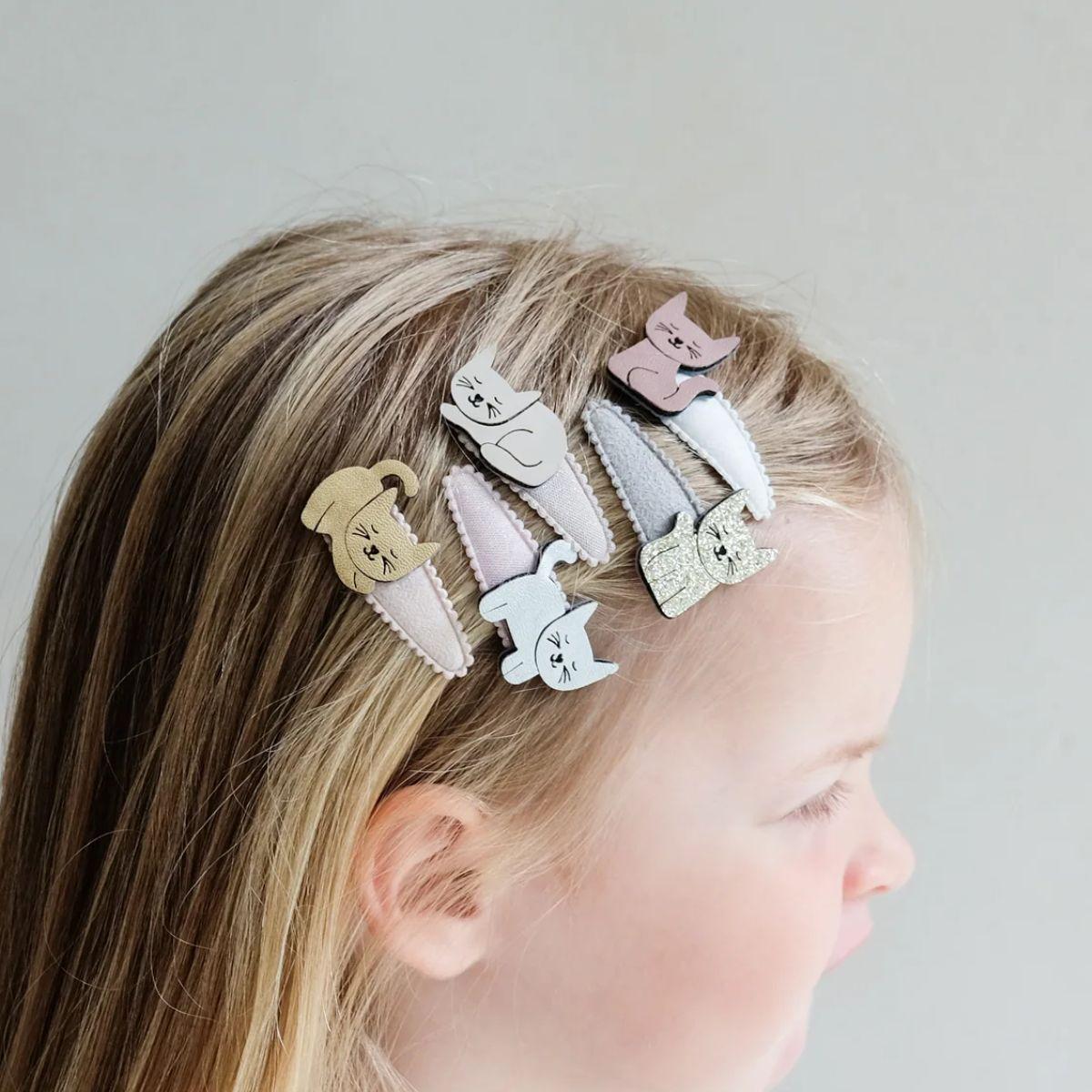 Child with decorative hair clips on a plain background