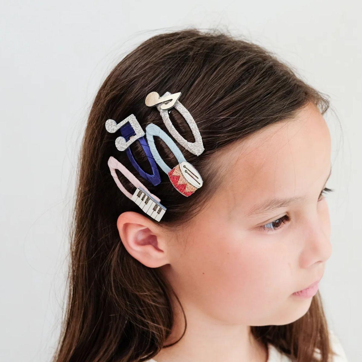 Girl with colorful hair clips in her hair on a white background