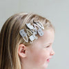 Child with decorative hair clips on a plain background