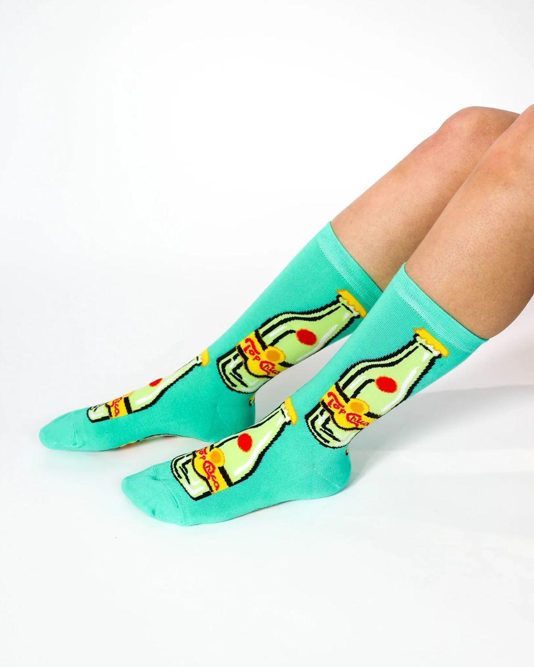 Teal socks with bottle design worn by a person on a white background