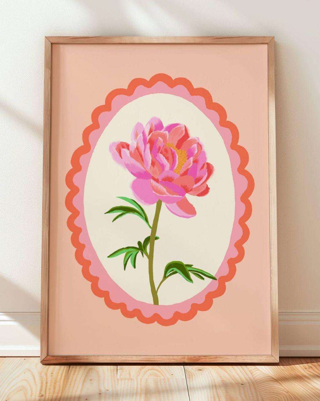 Framed artwork of a pink flower with a scalloped border on a peach background