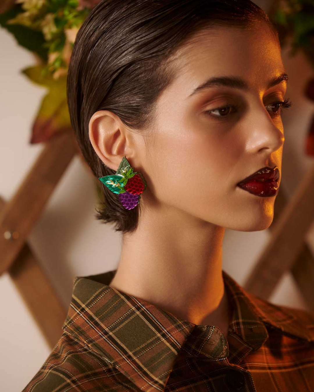 Woman wearing colorful earrings with a blurred indoor background