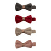 Four velvet bow clips in different colors on a white background