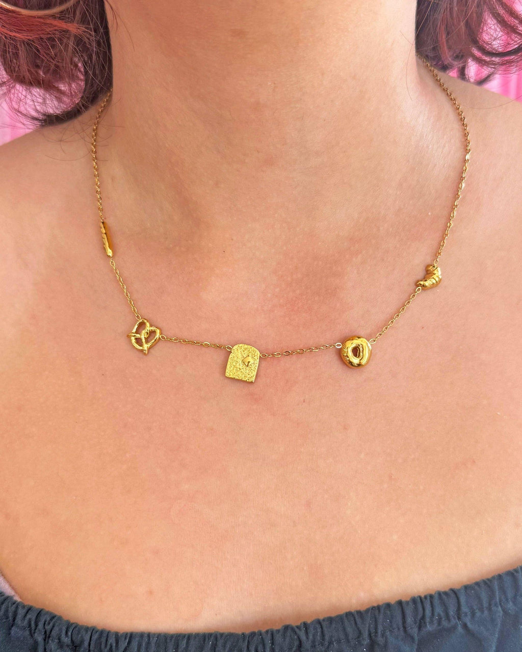 Gold necklace with bread charms on a person's neck