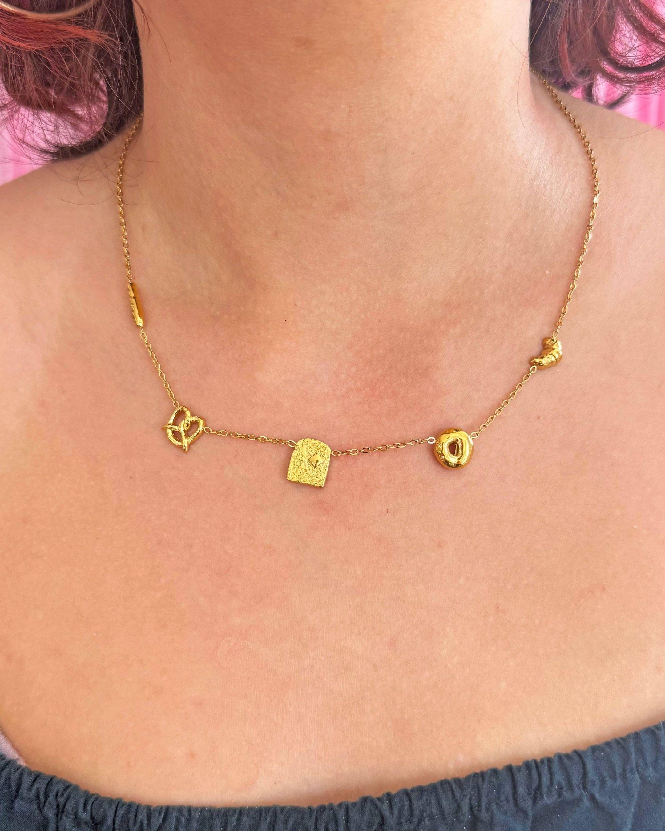 Gold necklace with bread charms on a person's neck