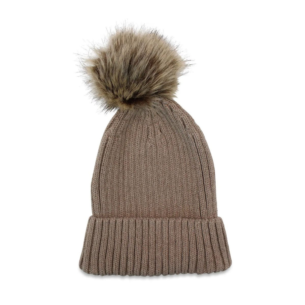 flatlay of a winter knitted beanie with faux fur pompom in latte