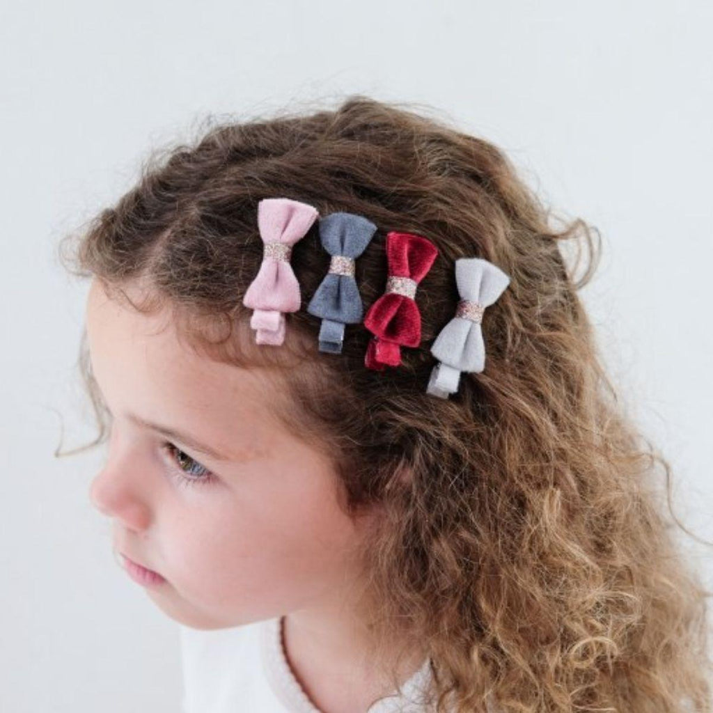 Child with colorful hair clips in their hair on a white background