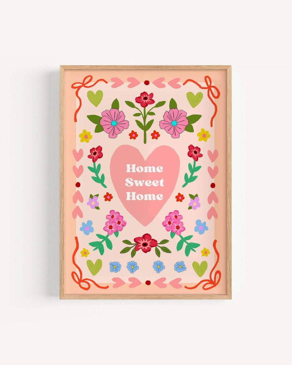 Decorative wall art with a pink heart and floral design on a white background