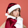 Child wearing a Santa hat and robe on a red background