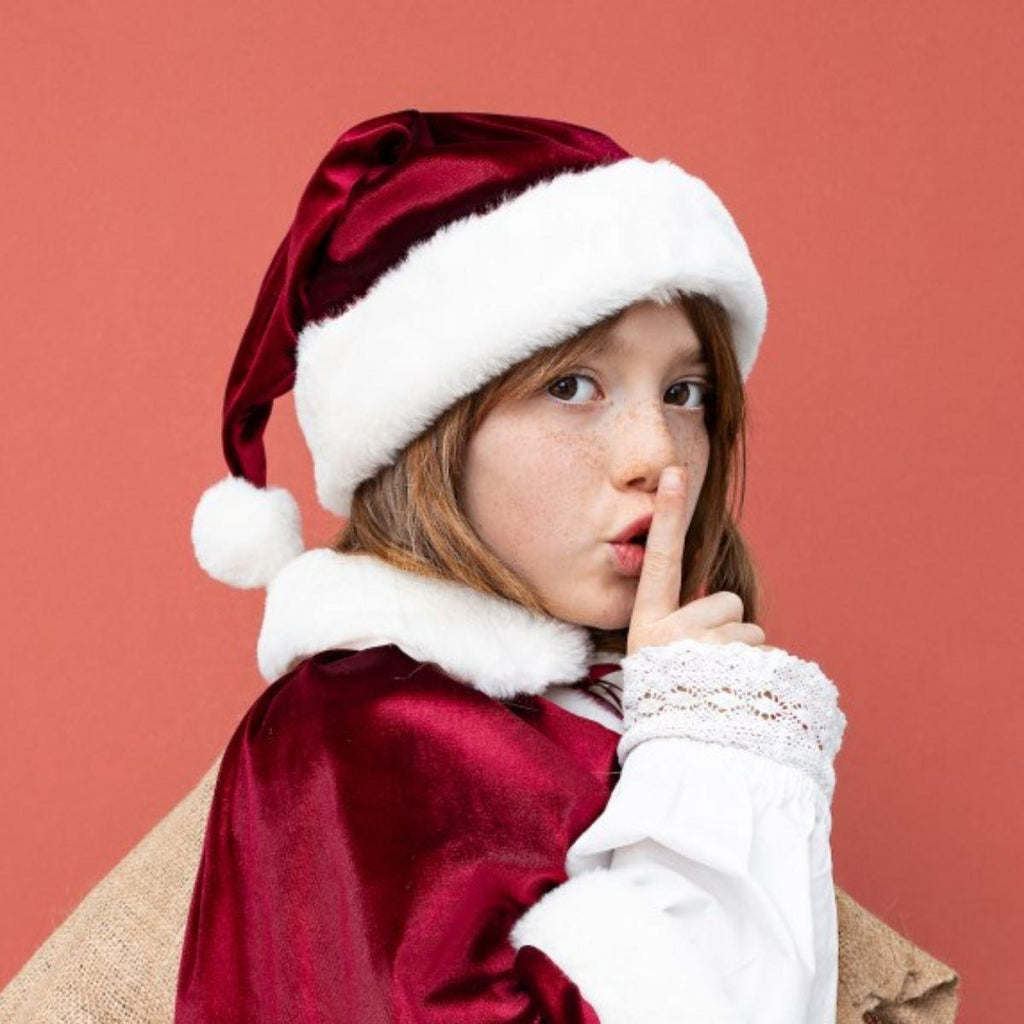 Child wearing a Santa hat and robe on a red background