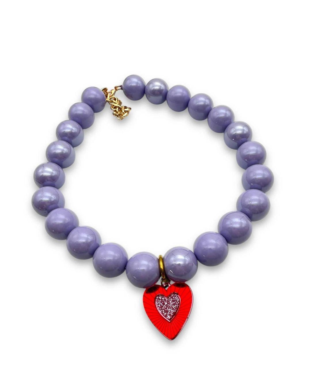 Lilac beaded necklace with a red heart-shaped charm on a white background