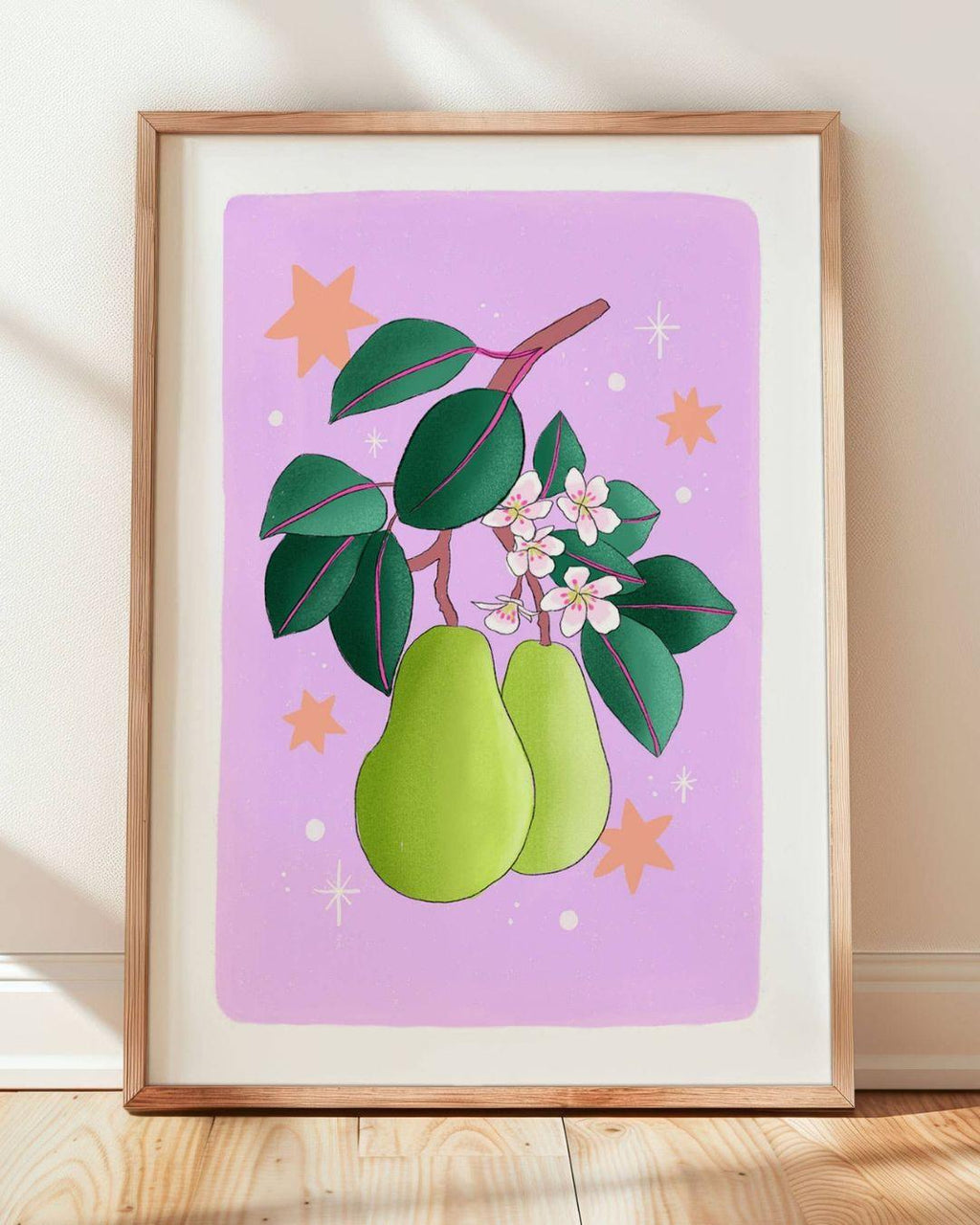 Framed artwork of green pears and leaves on a pink background
