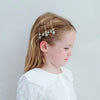 Female presenting child with star-shaped hair accessories on a plain background