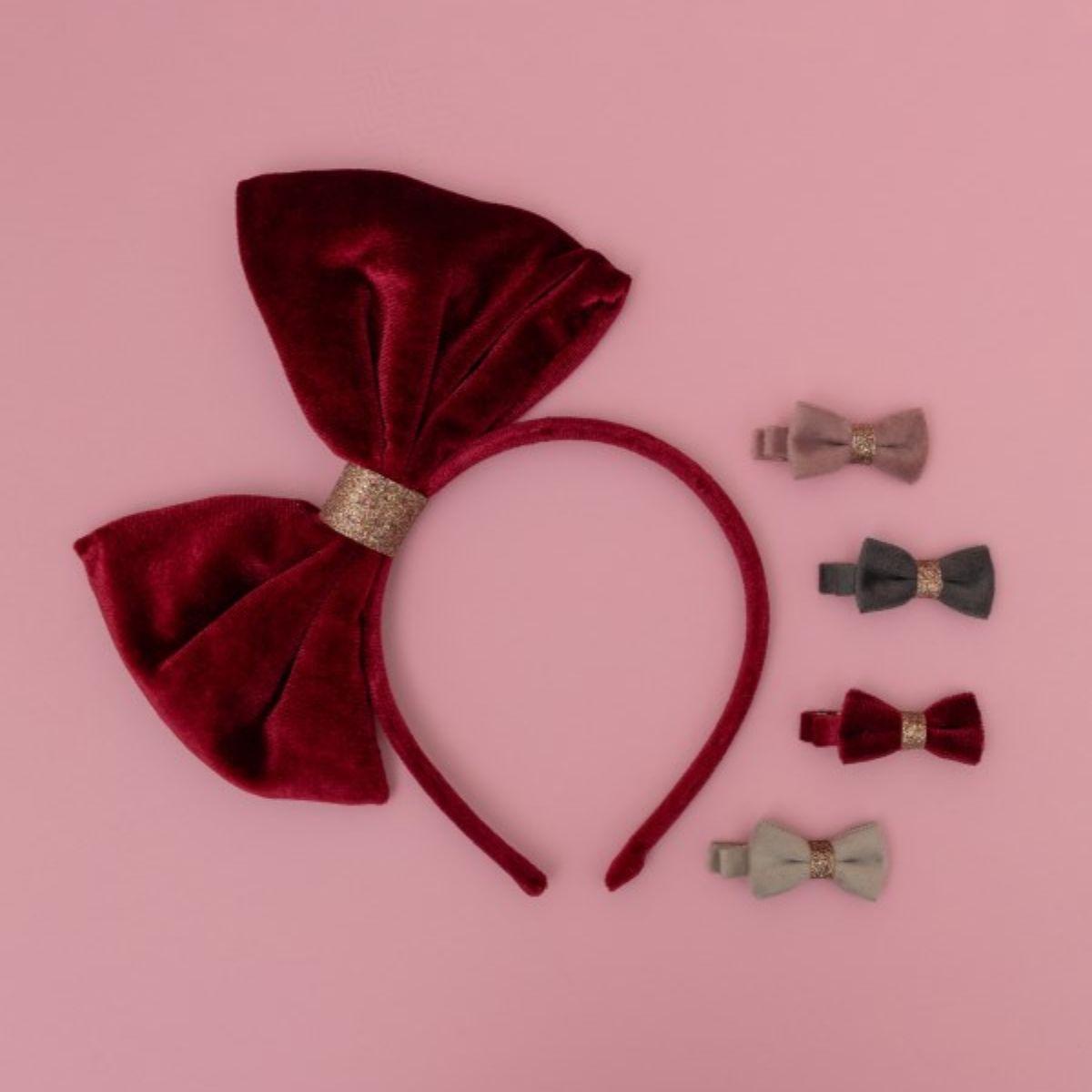 Red velvet headband with matching hair bows on a pink background