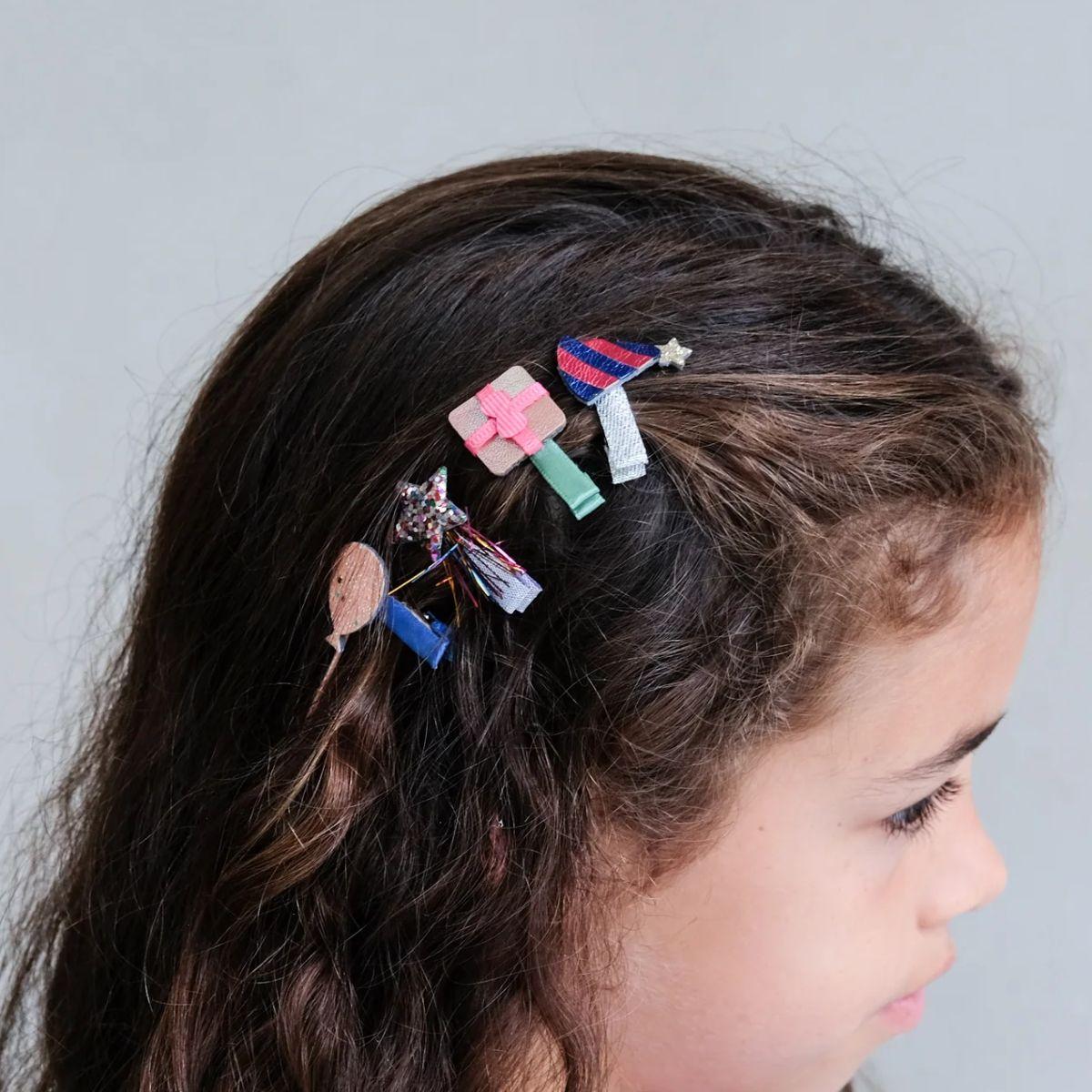 Child with decorative hair clips in their hair against a plain background