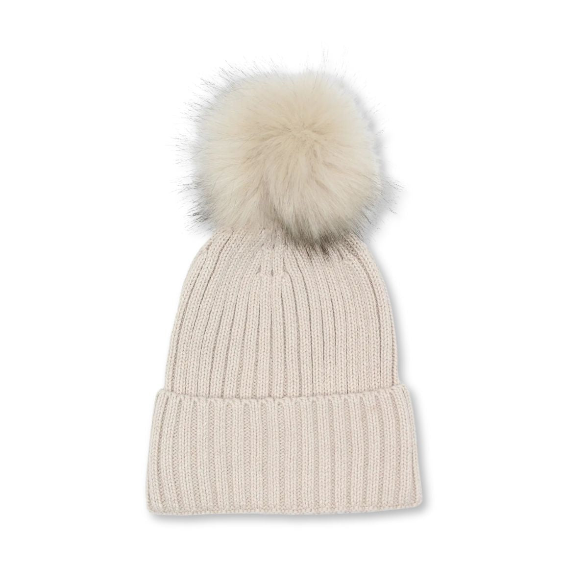 flatlay of a winter knitted beanie with faux fur pompom in cream