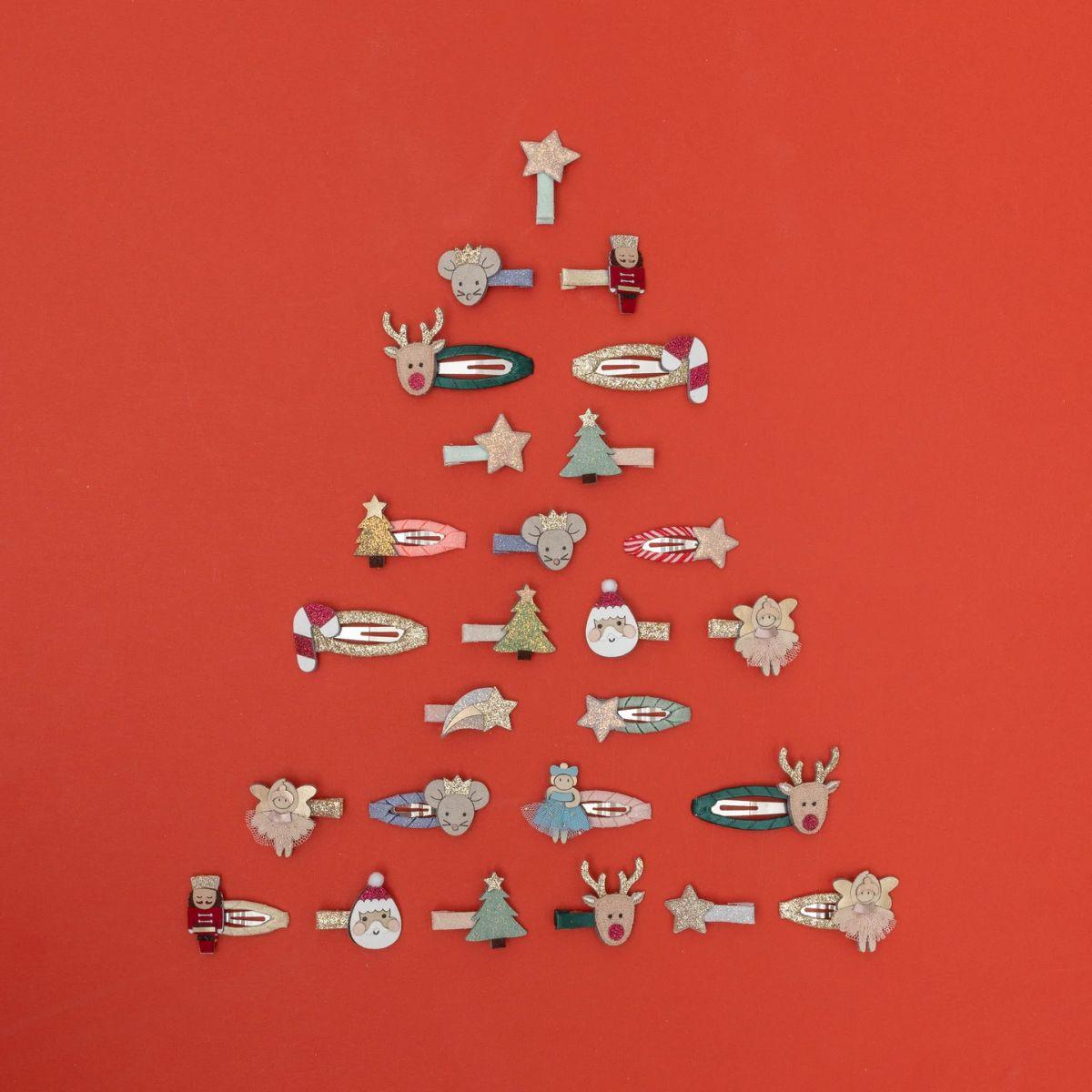 Collection of decorative pins arranged in the shape of a Christmas tree on a red background.