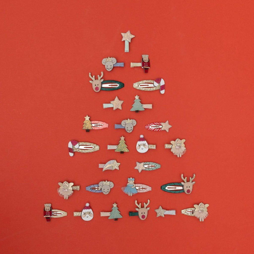 Collection of decorative pins arranged in the shape of a Christmas tree on a red background.