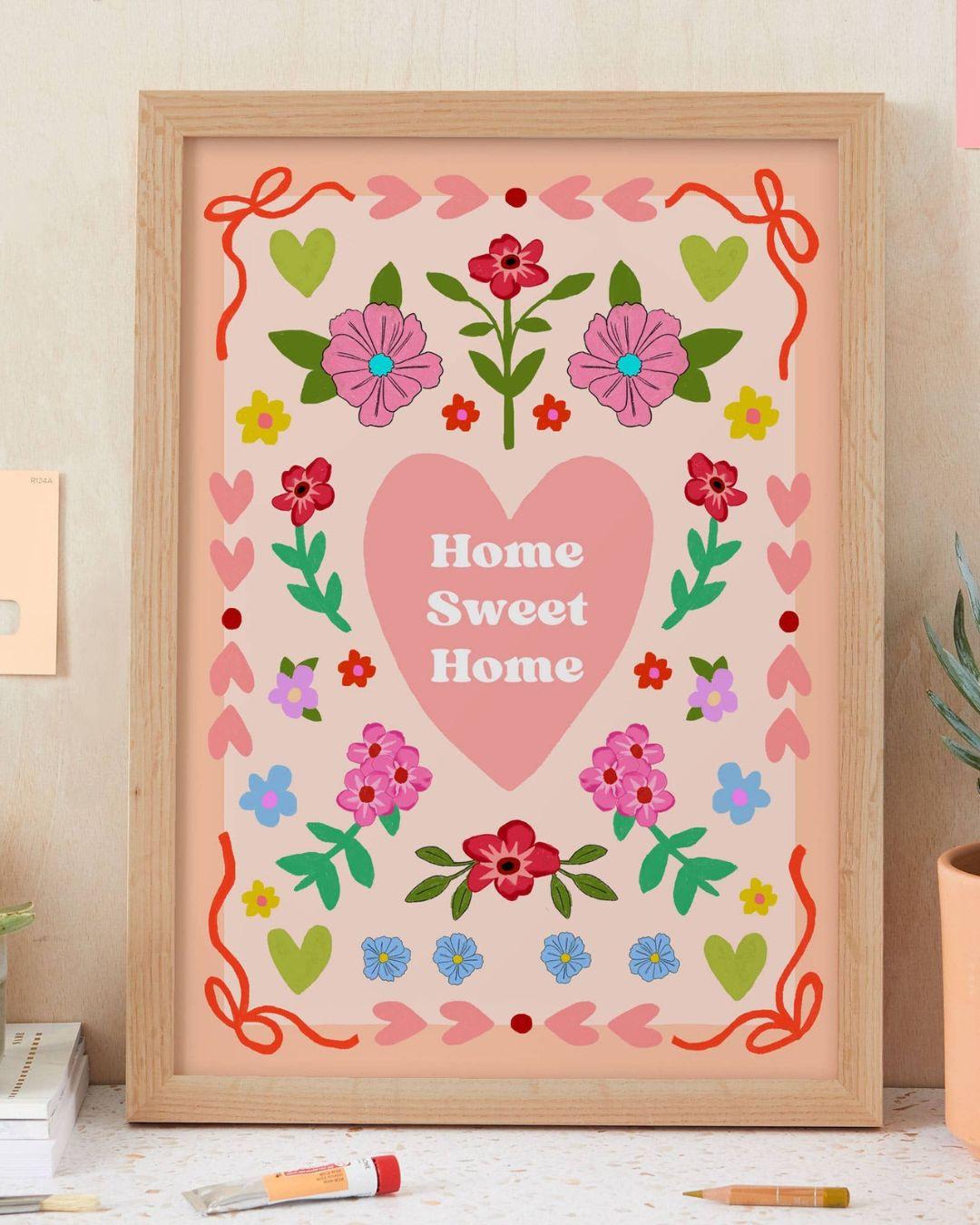 Framed artwork with 'Home Sweet Home' text and floral designs on a pink background.