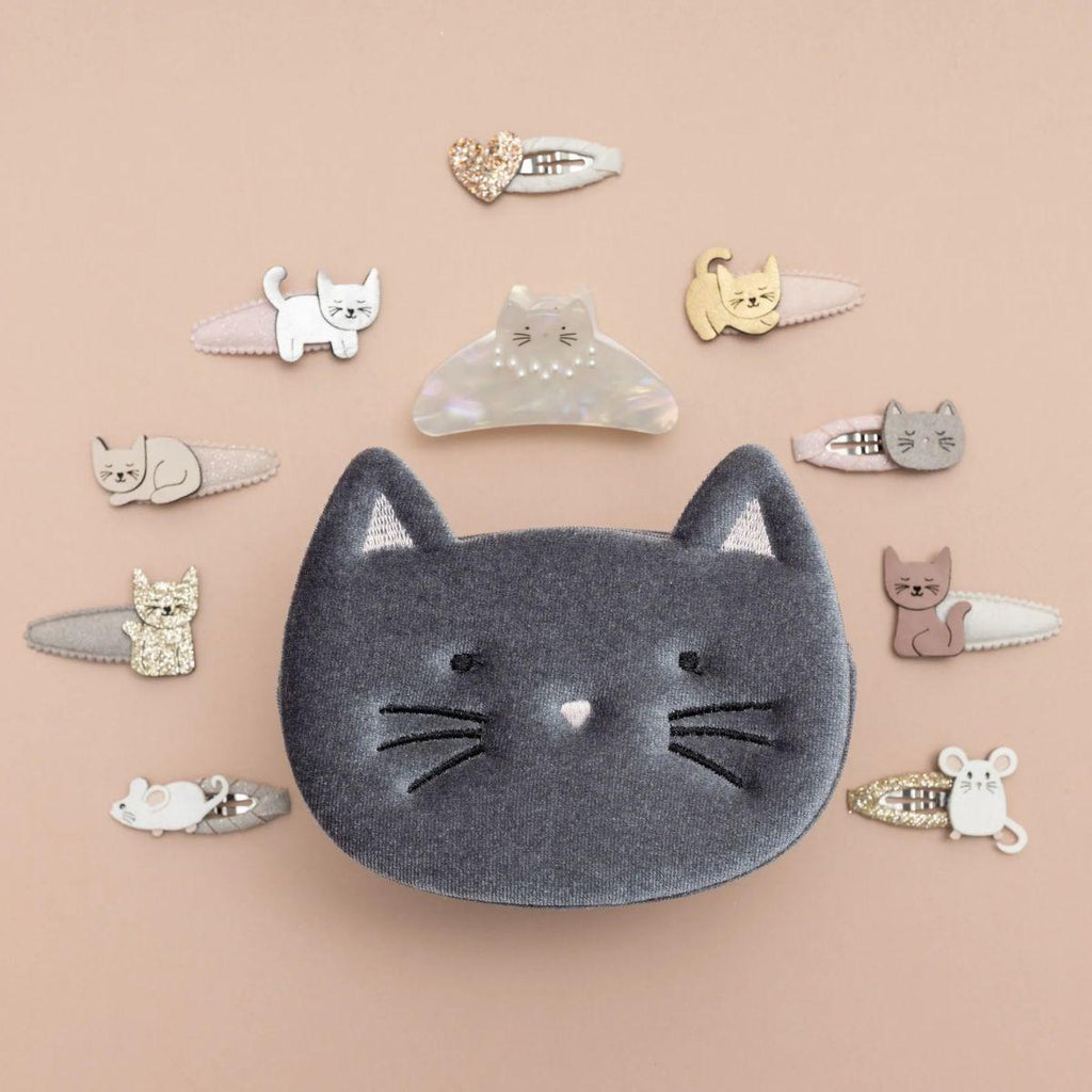 Collection of cat-themed hair clips on a beige background