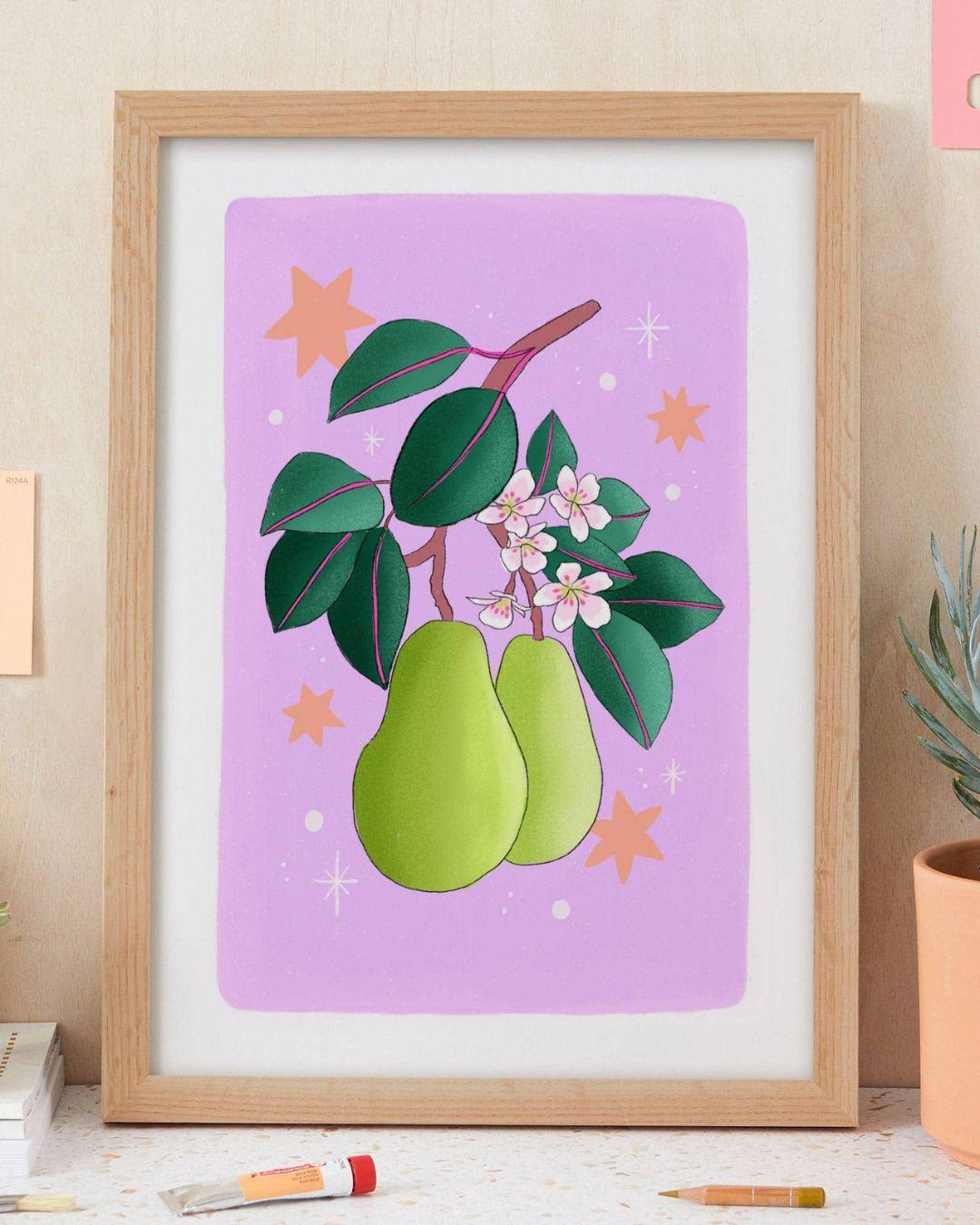Framed artwork of green pears on a purple background with leaves and flowers, placed on a surface.