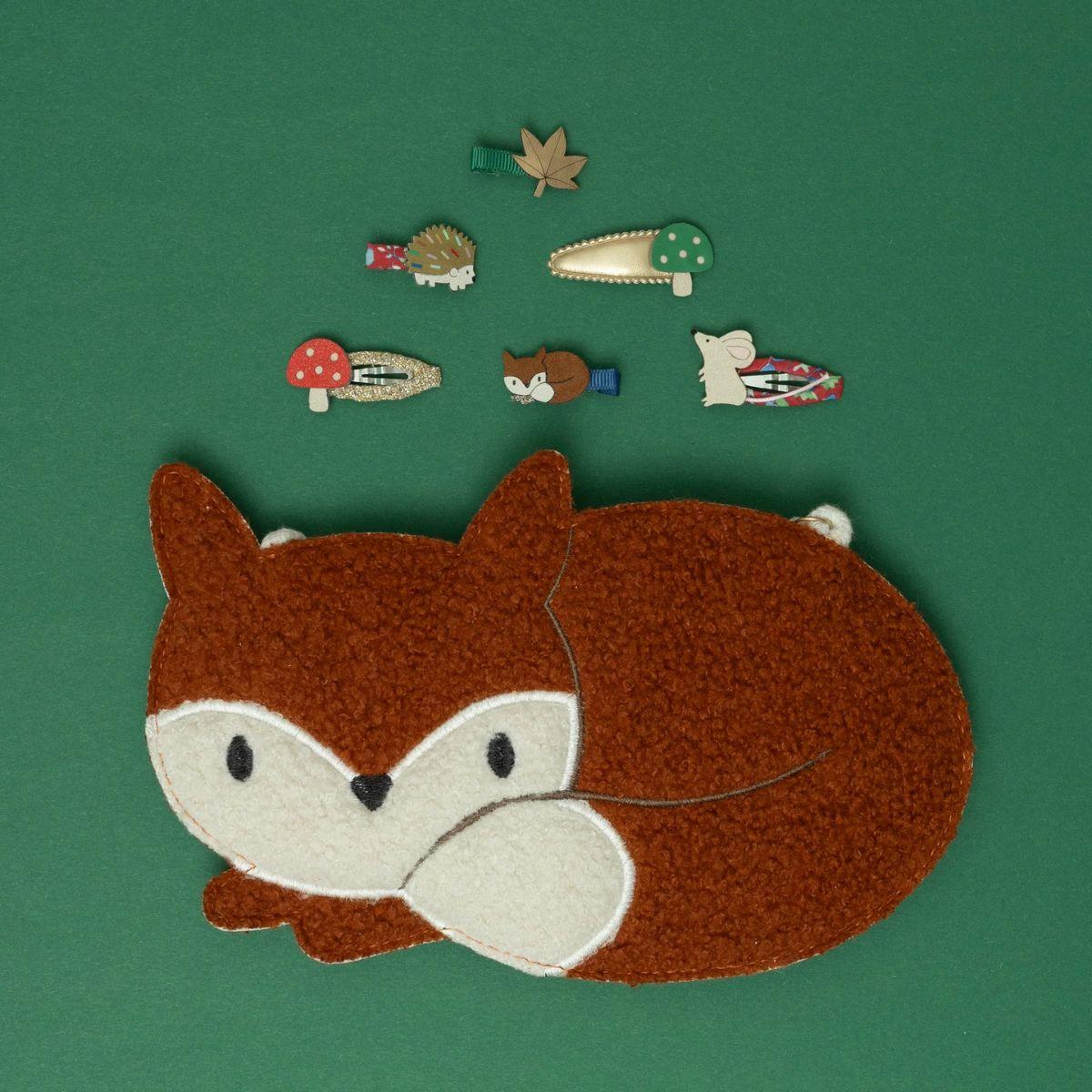 Embroidered patch of a fox on a green background with small embroidered animals.