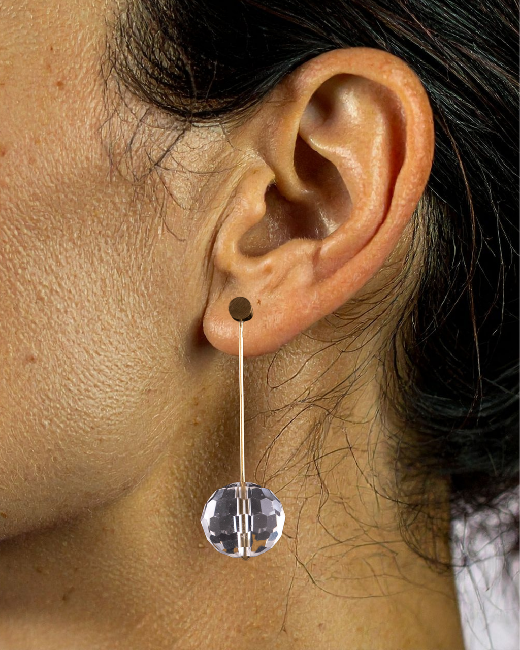 Close-up of an ear wearing a clear crystal earring.