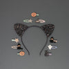 Black glitter cat ear headband with Halloween-themed hair accessories on a gray background