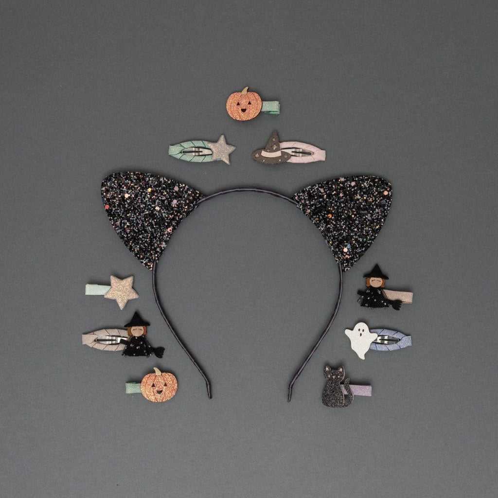 Black glitter cat ear headband with Halloween-themed hair accessories on a gray background