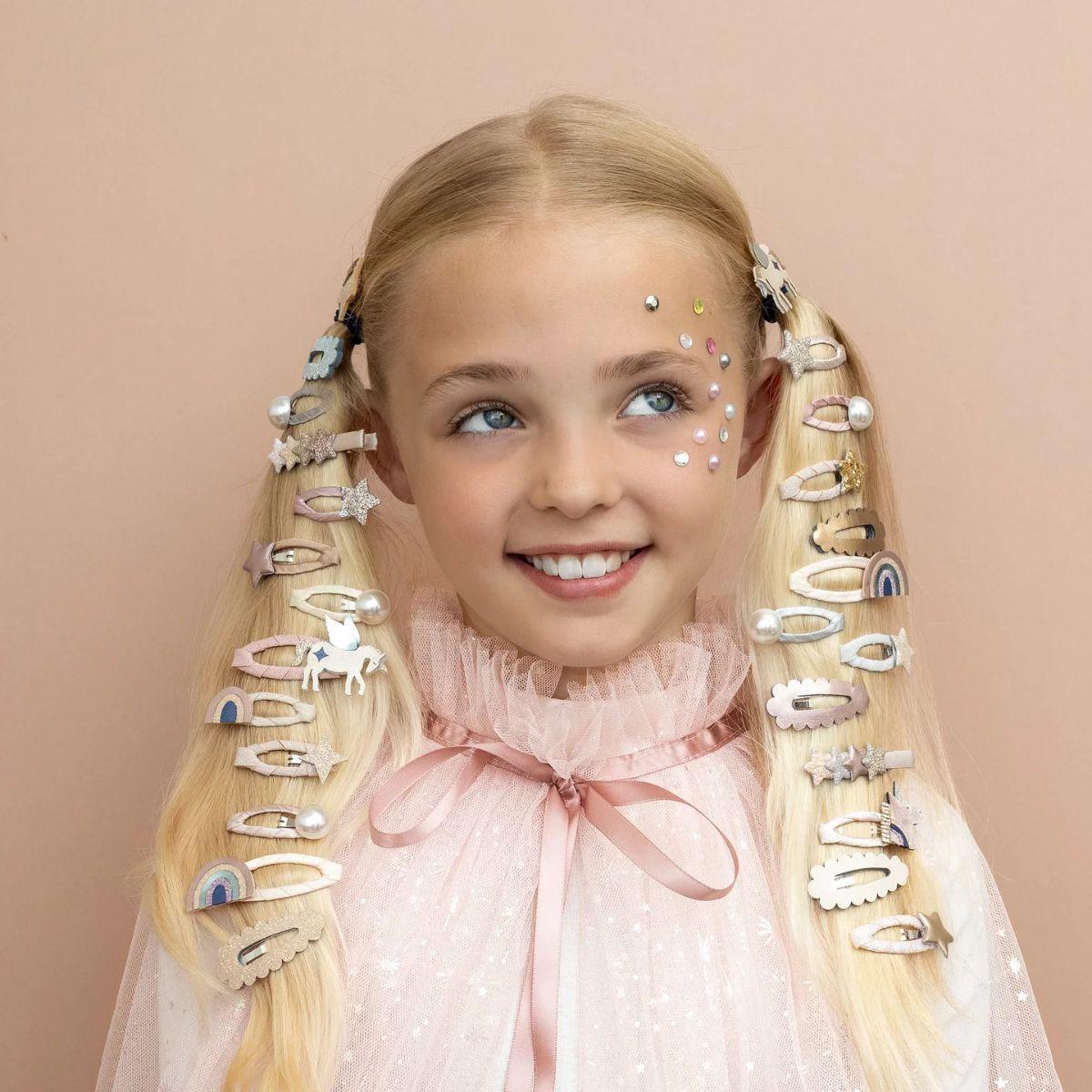 Young girl with decorative hair clips on a beige background