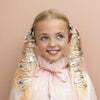 Young girl with decorative hair clips on a beige background