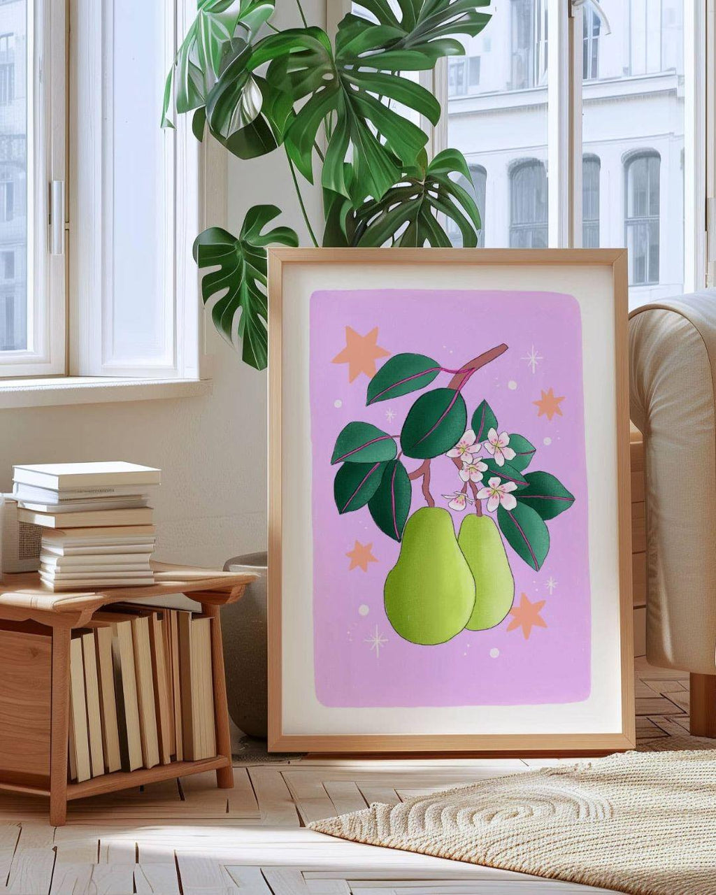 Framed artwork of pears on a pink background in a room with books and a plant.