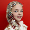 Young girl with a variety of decorative hair accessories on a red background