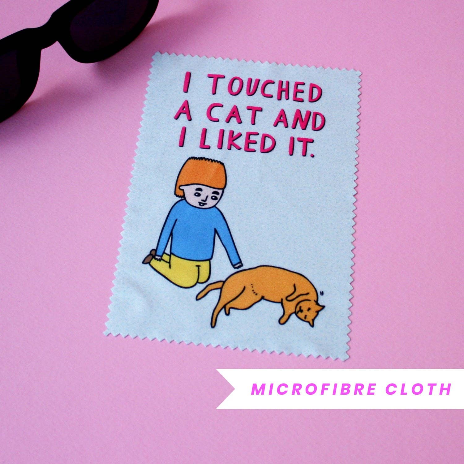 Microfibre cloth with a cartoon design of a boy and cat, text 'I touched a cat and I liked it.' on a pink background.