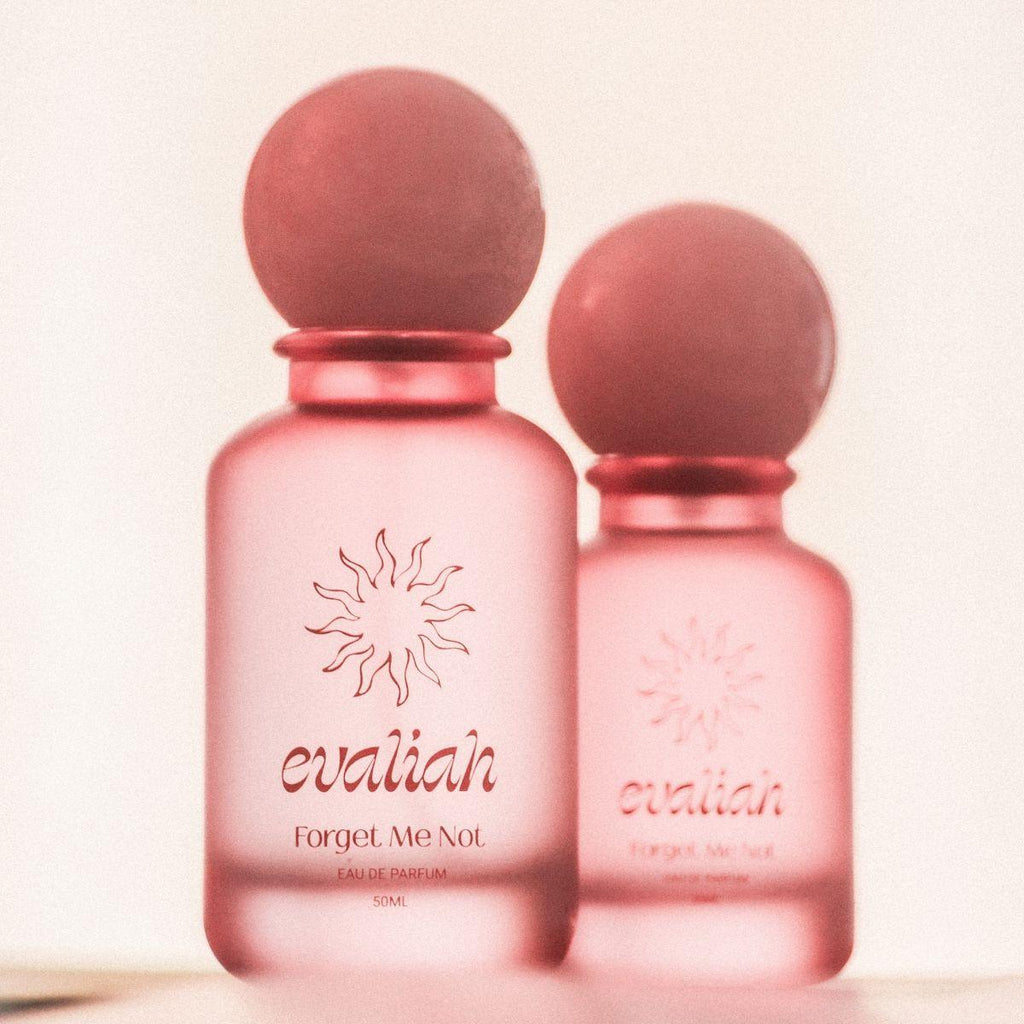 Two pink perfume bottles with 'evaliah' branding on a light background