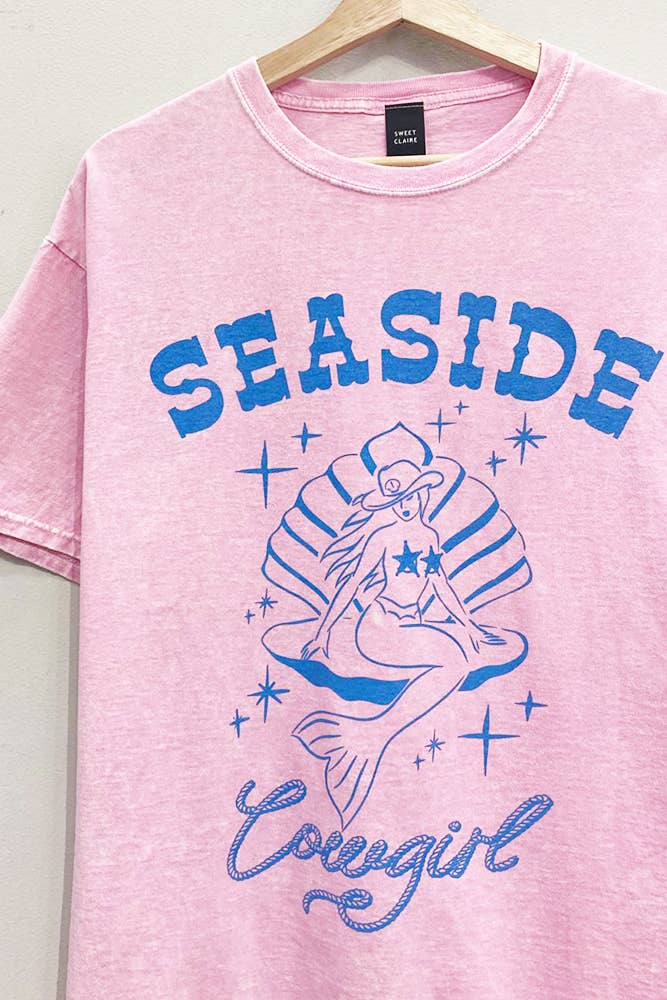 Pink t-shirt with blue 'Seaside Cowgirl' design featuring a mermaid on a hanger.