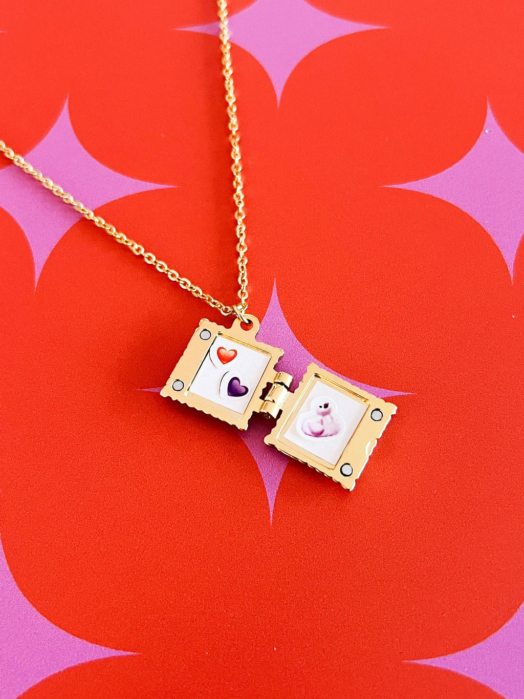 Open Gold necklace locket with images inside on a red and pink starburst background