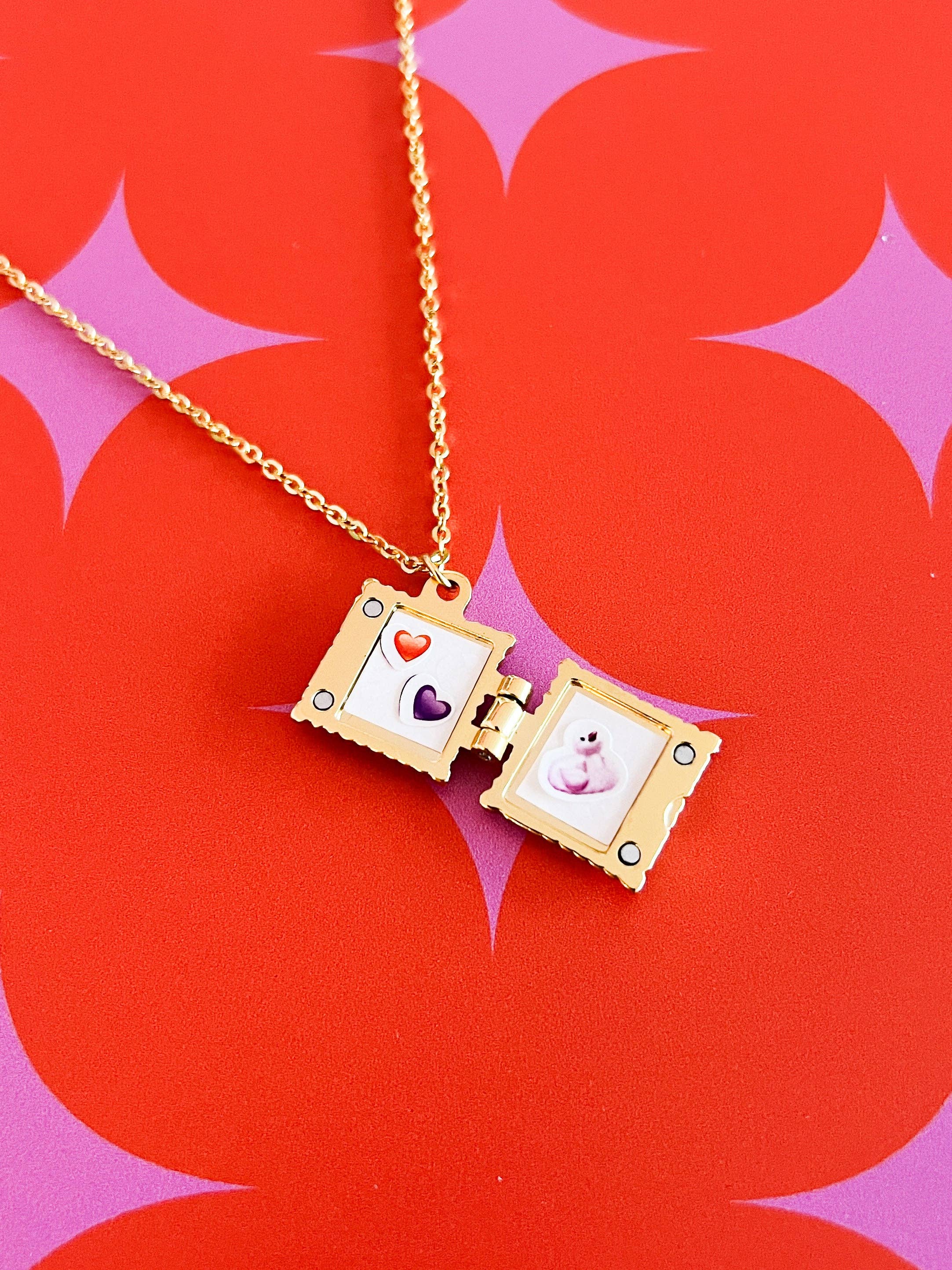 Open Gold necklace locket with images inside on a red and pink starburst background