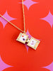 Open Gold necklace locket with images inside on a red and pink starburst background