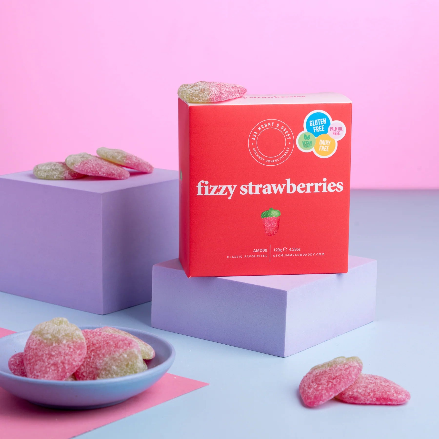 Box of 'fizzy strawberries' with gummy candies on a pink and blue background