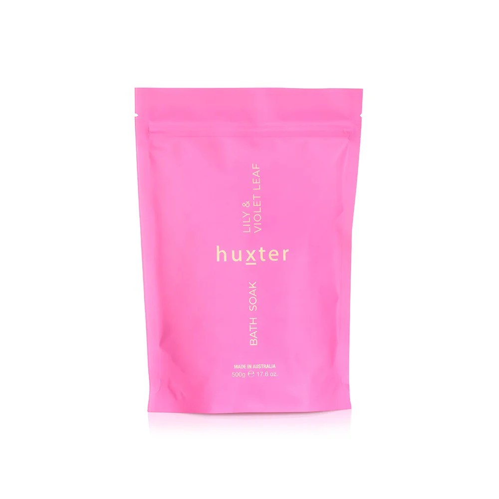 A pink package of Huxter brand Bath Soak with the text '500g' and 'Lily & Violet Leaf' on it.