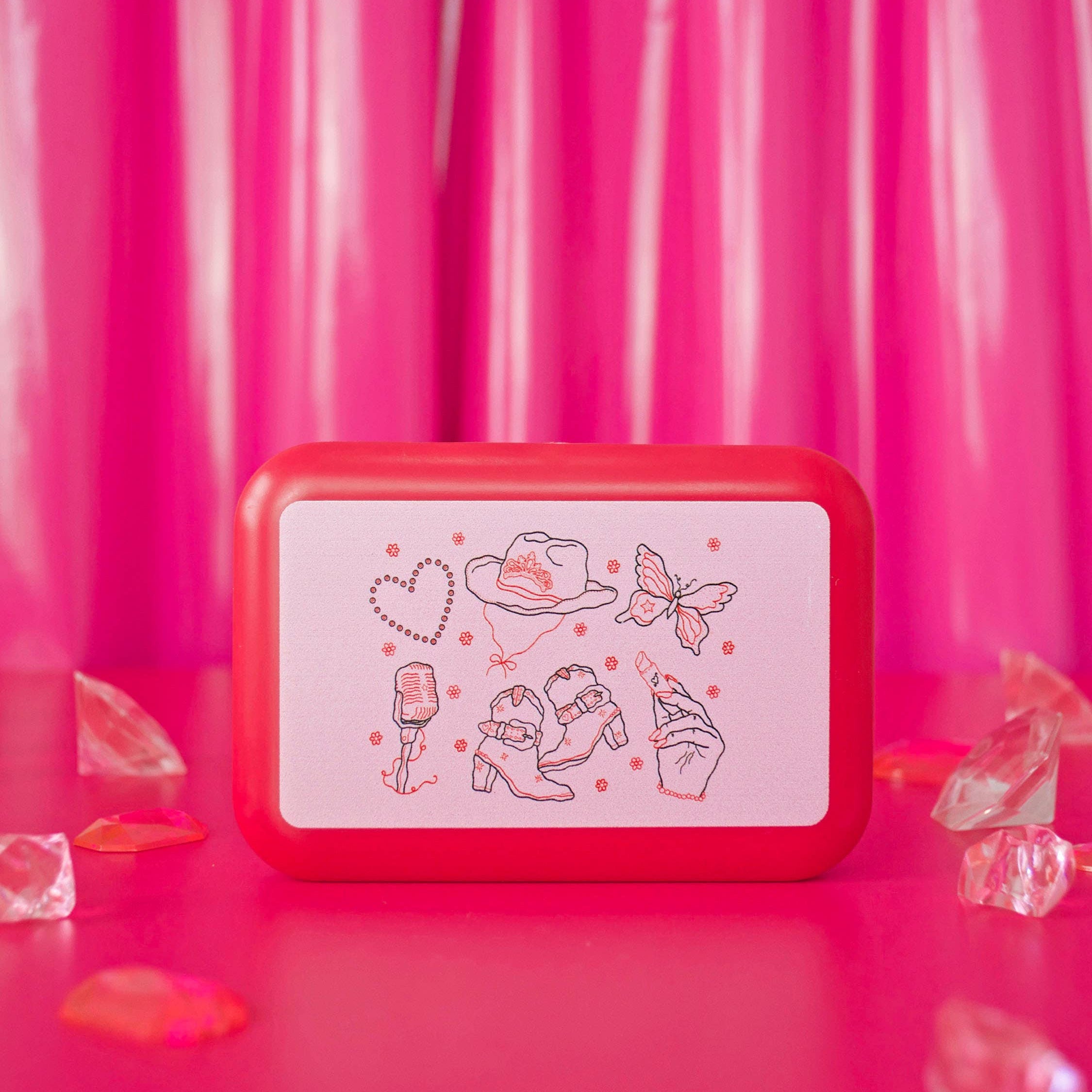 Red rectangular box with white label featuring illustrations on a pink background