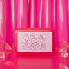 Red rectangular box with white label featuring illustrations on a pink background
