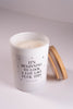 Candle in a white container with text on a light gray background