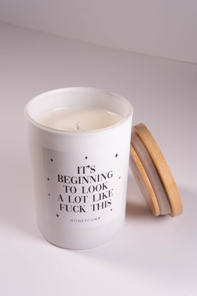 Candle in a white container with text on a light gray background