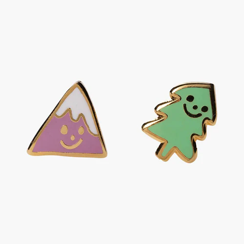 A pair of asymmetrical cloisonne stud earrings, one shaped like a mountain with a smiling face and the other like a tree, both gilded in 22 karat gold and set against a white background.